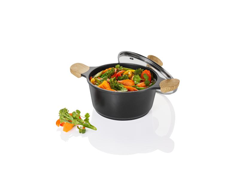 Zwarte pan met groenten, glazen deksel.