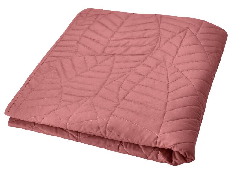 Roze gewatteerde sprei met geometrisch patroon.