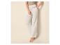 Witte mousseline wide-leg broek met trekkoord en olijfgroene crop top, met witte sandalen met hak.