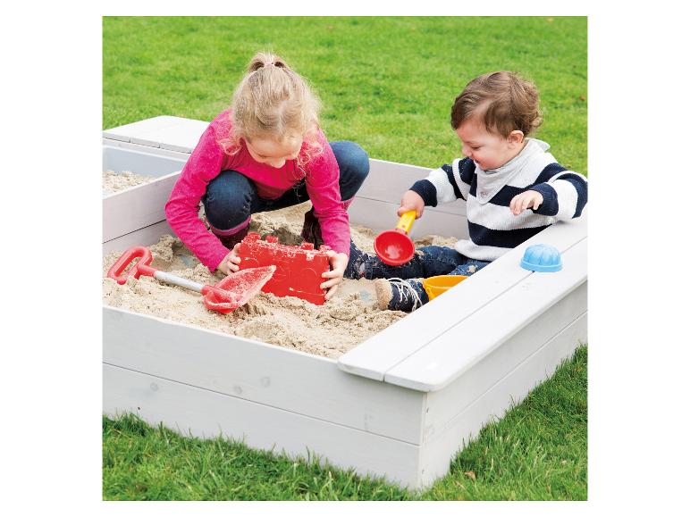 Twee kinderen spelen in een houten zandbak.