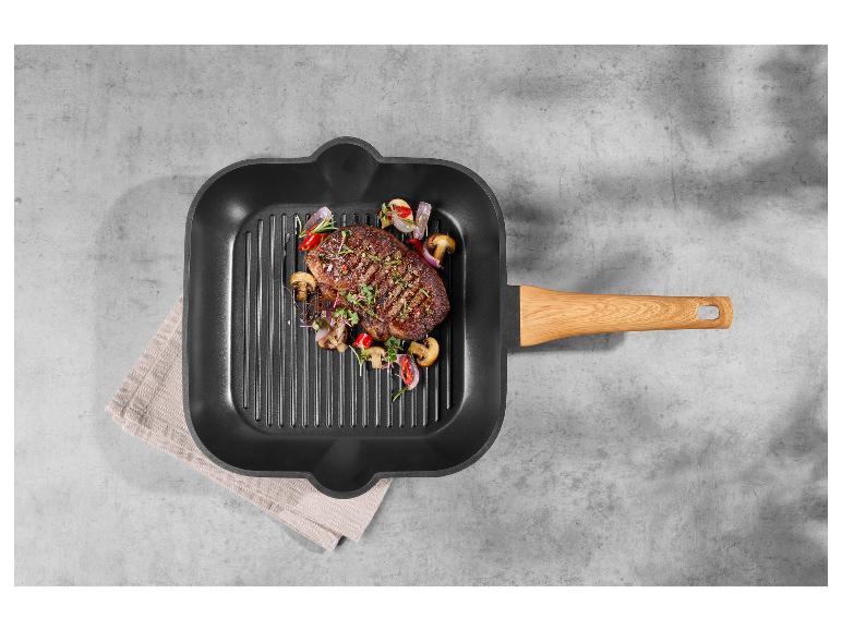 Biefstuk met groenten in een grillpan met houten handvat.