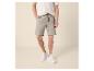 Man in gebreid shirt met korte mouwen en linnen short met trekkoord.