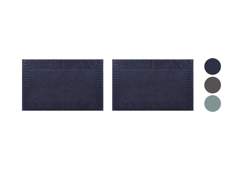 Twee marineblauwe rechthoekige badmatten met een gestructureerd reliëfpatroon.