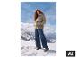 Vrouw in ESMARA® Premium gewatteerde jas en jeans in besneeuwde bergen. [AI-gegenereerde afbeelding]