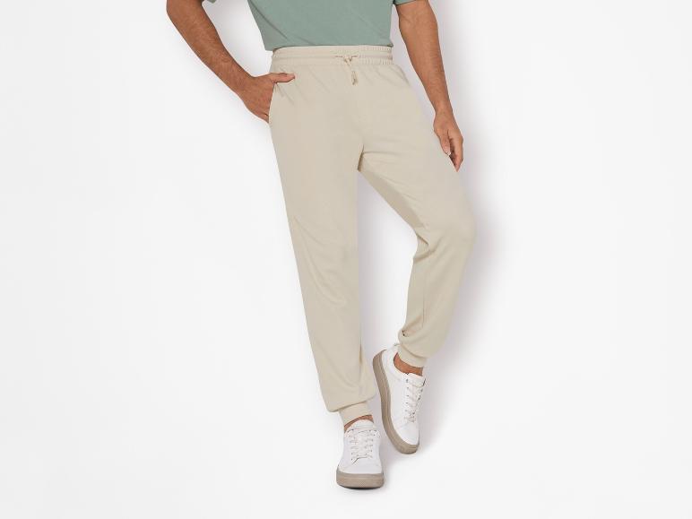 Beige joggingbroek en witte sneakers: casual look.