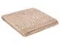 Opgevouwen beige handdoek met geometrisch patroon en geborduurd logo.