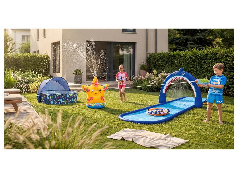 Kinderen spelen in de tuin met een opblaasbare zeestersproeier en een haaienwaterglijbaan.