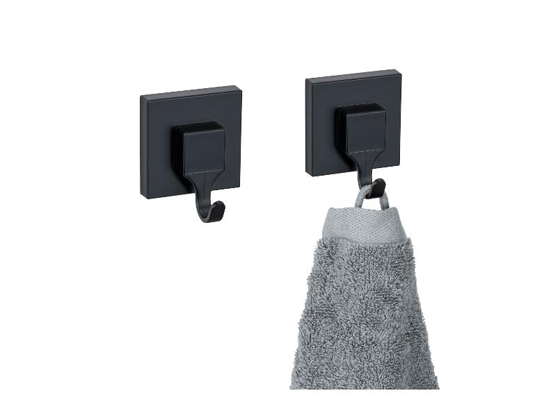 Twee zwarte zelfklevende haken, waarvan één een handdoek draagt.