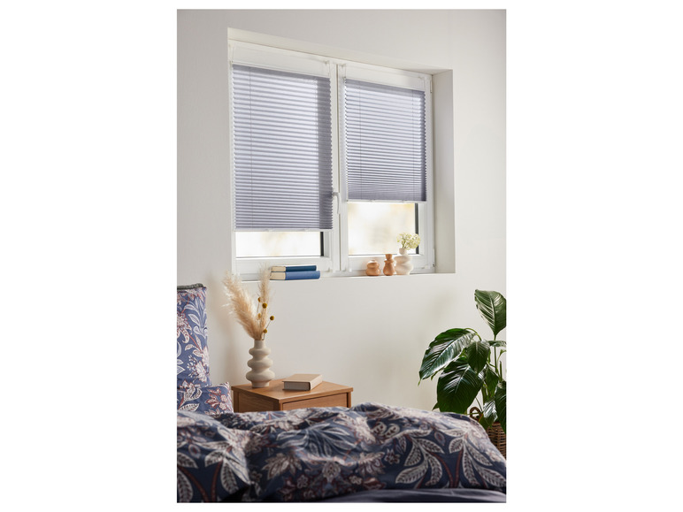 Grijze plissé gordijnen voor een slaapkamerraam