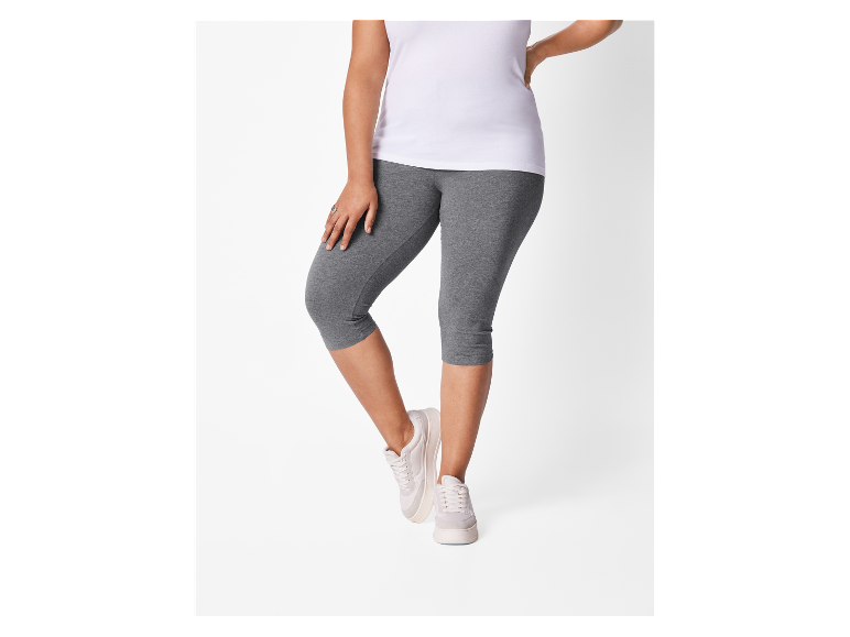 Vrouw in wit t-shirt en grijze leggings.