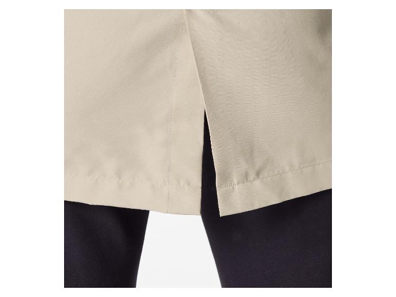 Achtersplit van een beige rok of jurk over een zwarte broek.