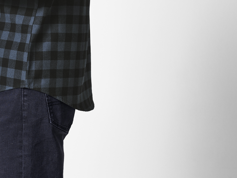 Donkerblauw en zwart geruite overhemd over een donkere jeans.