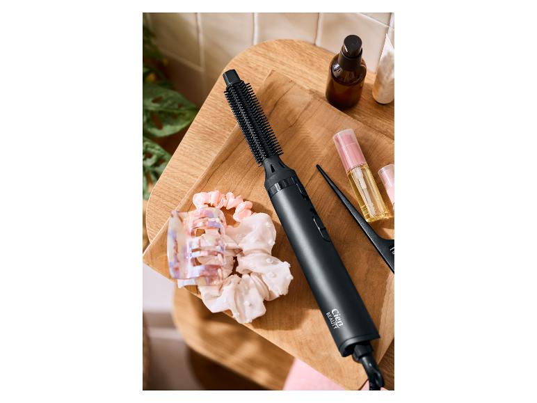 Cien Beauty heteluchtborstel, haaraccessoires en haarverzorgingsproducten op een houten dienblad.