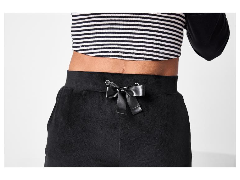 Gestreept topje en zwarte broek met satijnen strik