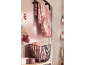 Roze handdoeken met bloemenpatroon hangen aan een rek en liggen in een mand in de badkamer.