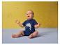 Baby in blauw haaien-T-shirt speelt met zeepbellen.
