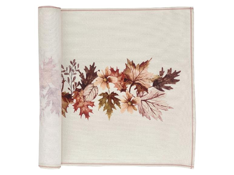 Crèmekleurige tafelloper met herfstbladeren en bloemen in bruine en oranje tinten.