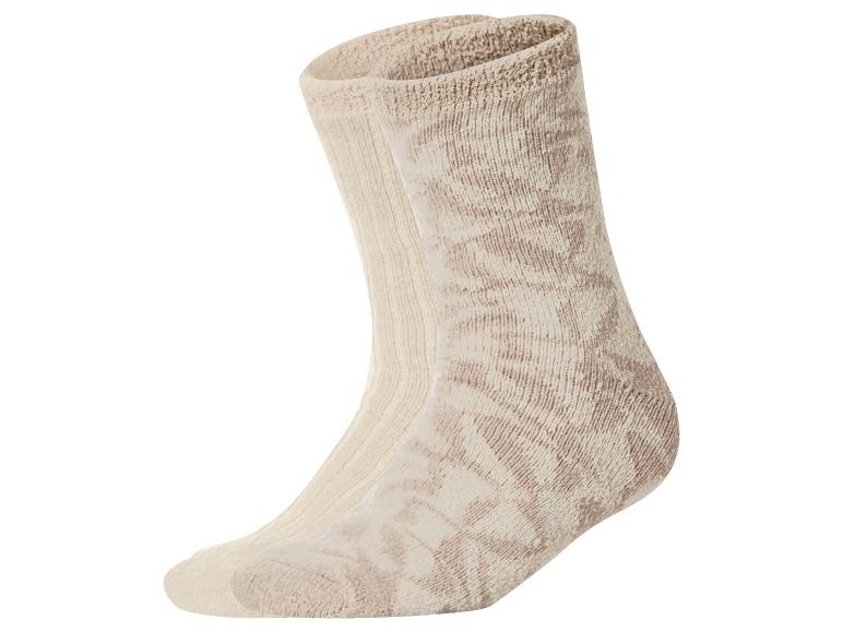 Een paar beige sokken met een subtiel patroon, de een achter de ander.