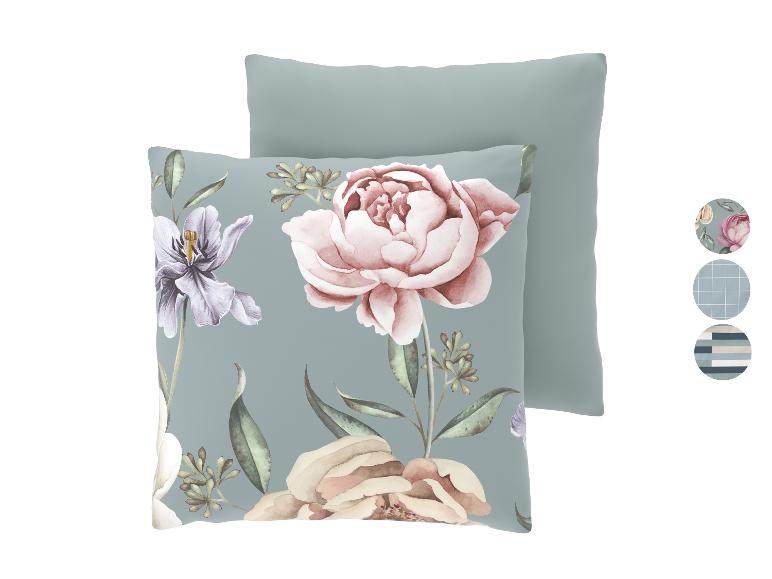Twee kussens, één met bloemen- en bladpatroon, de andere effen, met stofstalen ernaast.