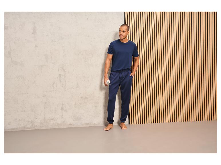 Man in donkerblauwe trainingsbroek en T-shirt.