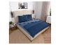 Slaapkamer met bed met blauw gestreept beddengoed, nachtkastjes en decoraties.