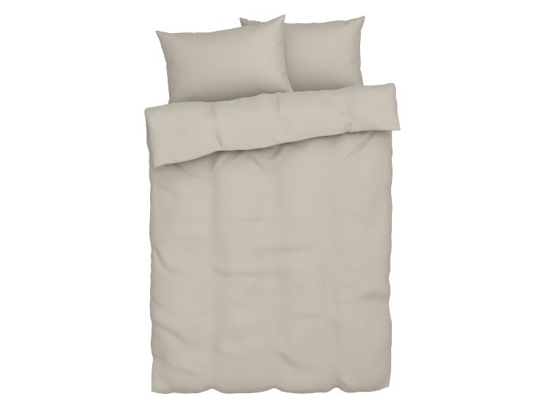 Beige beddengoed met twee kussenslopen en een kussen.