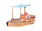 Houten zandbak in bootvorm met blauw zonnescherm, stuurwiel en reddingsboei