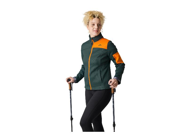 Vrouw in Craft sportjas en wandelstokken.