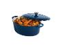 Blauwe ovale braadpan met gebraden kip en groenten, deksel op een kier.