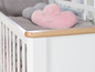 Wit babybed met houten rand en roze kussen