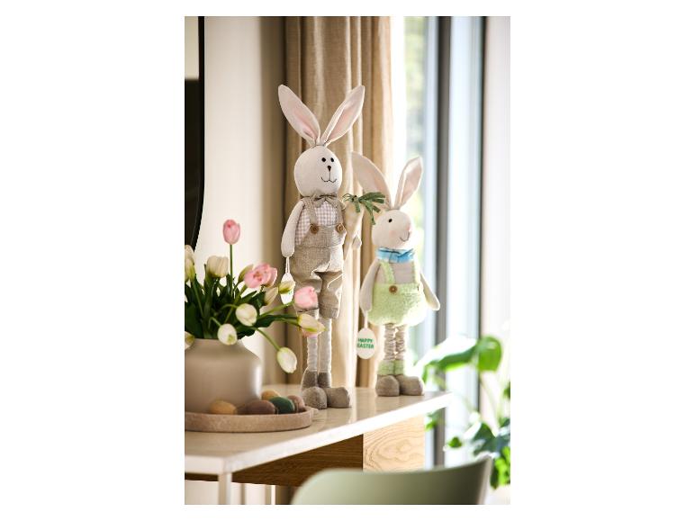 Paashaasdecoraties met tulpen en decoratieve eieren op een witte tafel.