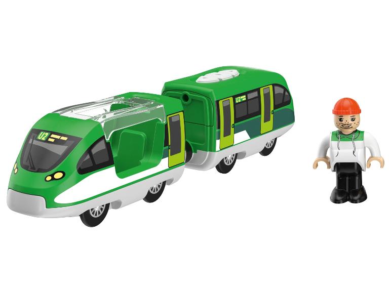 Groene speelgoedtrein met twee wagons en een figuur op een witte achtergrond.