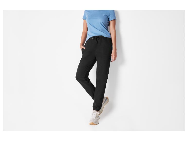 Zwarte joggingbroek met witte sneakers.