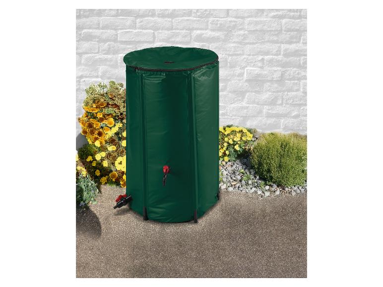 Groene regenton met kraan, buiten geplaatst bij een witte bakstenen muur en bloemen.