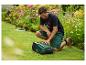 Man knielt naast robotmaaier in tuin