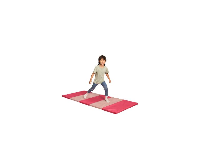 Meisje oefent op een roze en beige turnmat.