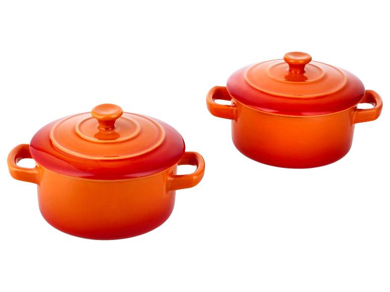 Twee feloranje keramische ovenschalen met deksels en handvatten.