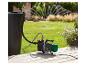 Parkside regenwaterpomp aangesloten op een tank en sproeier in de tuin.
