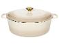 Crèmekleurige geëmailleerde gietijzeren braadpan met gouden knop op het deksel.