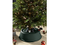 Verlichte kunstkerstboom met groene voet en feestelijke decoraties.