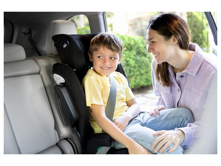 Lachende moeder en kind in een kinderzitje in de auto.