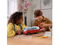 Kinderen zetten aan tafel een 3D-puzzel van een rood-witte kampeerbus in elkaar.