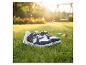 Kindersneakers met autodesign op groen gras met paardenbloemen en speeltuin op de achtergrond.