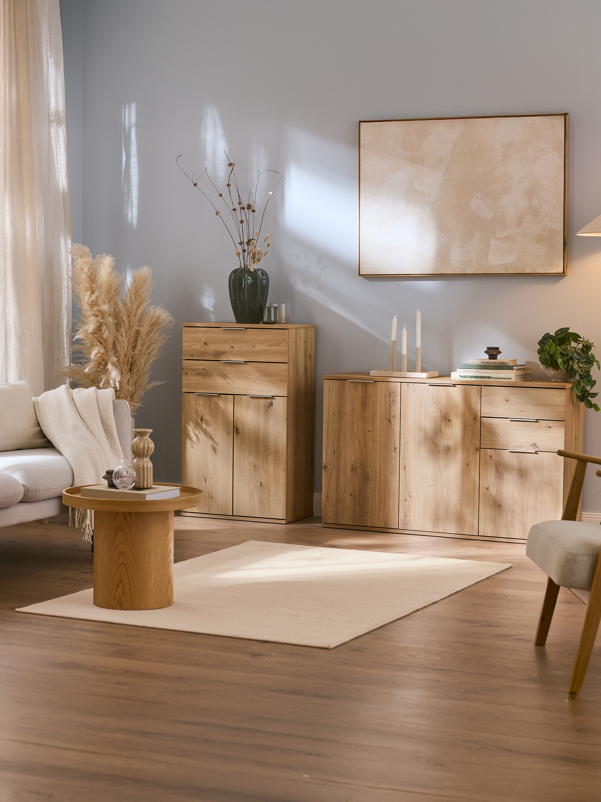 Woonkamer met houten kasten, bank, salontafel en neutrale decoratie.