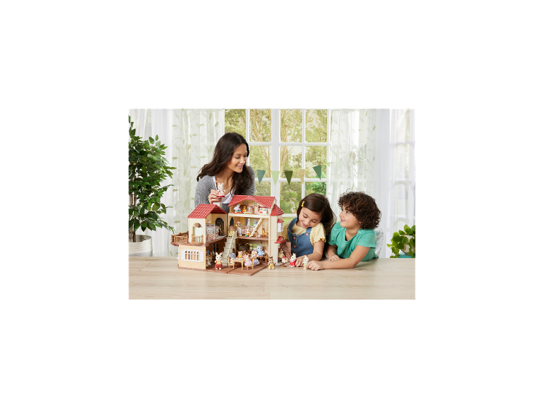Vrouw en kinderen spelen met een poppenhuis en dierenfiguren.