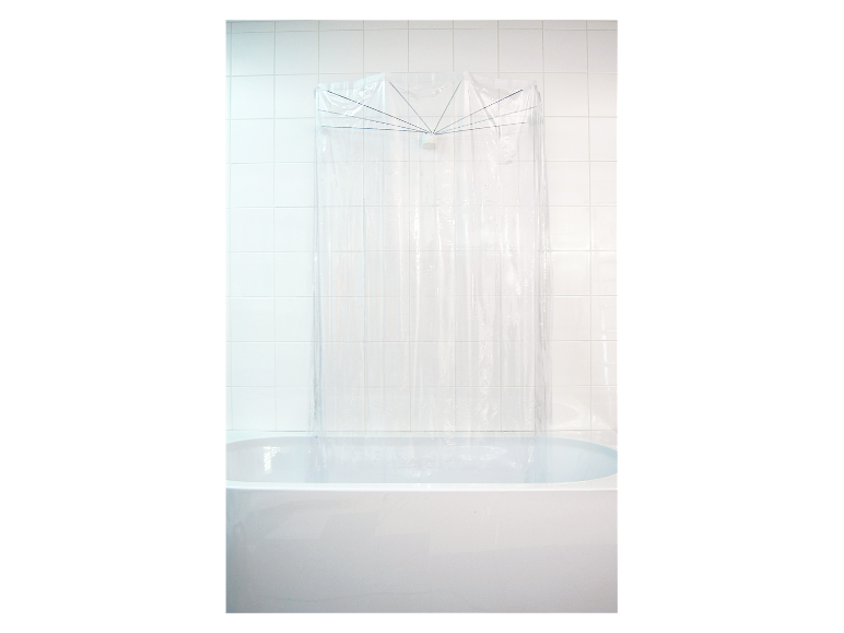 Een transparant plastic douchegordijn met metalen beugel in een wit bad.
