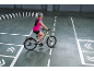 Vrouw op elektrische fiets op een trainingsparcours met witte kegels.