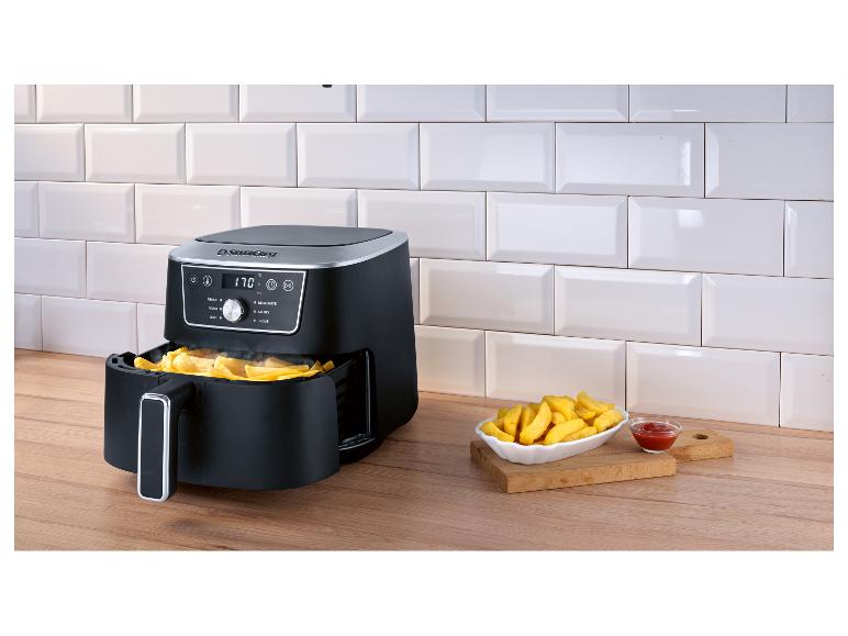 SilverCrest airfryer met aardappelpartjes en ketchup op een houten aanrecht.