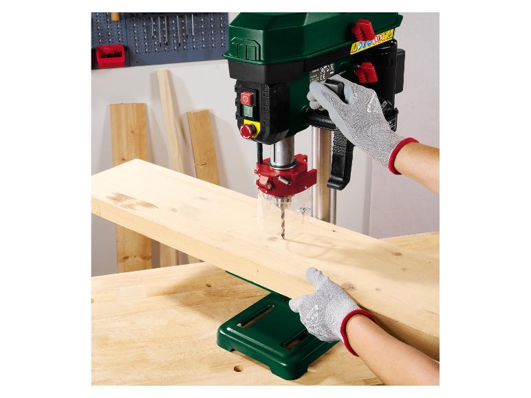 Persoon gebruikt een Parkside kolomboormachine om een houten plank te boren.