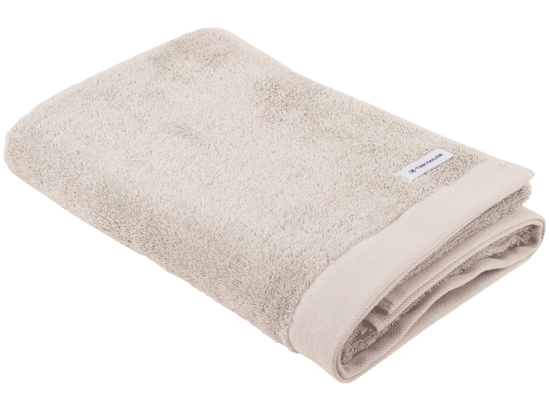 Opgevouwen beige badhanddoek met een wit etiket.
